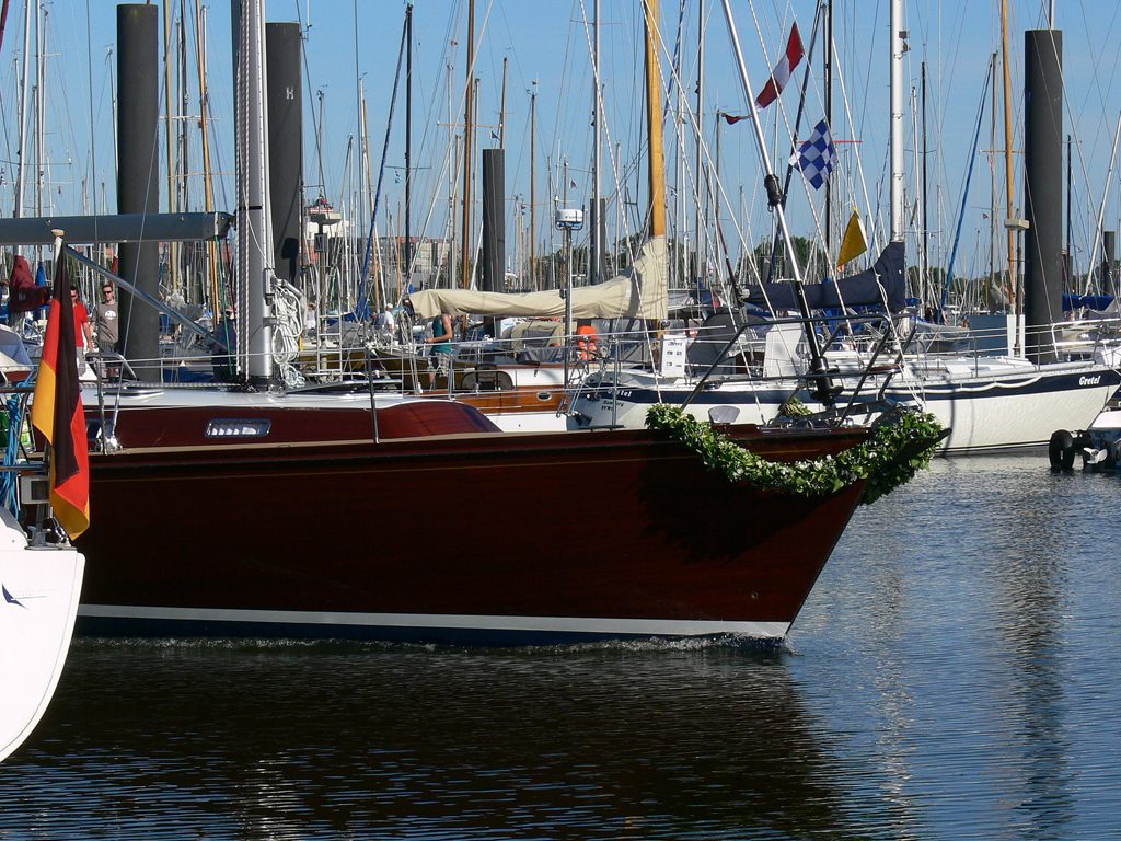 Mahagoni-Motoryacht mit Girlande am Bug im Hafen