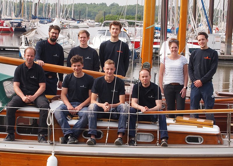 Das Team der Wegener Jachtwerft auf einer Holzyacht im Hafen